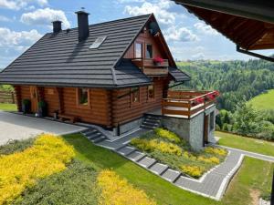 a small wooden house with a porch and a balcony at Osada Małysze in Jaworzynka