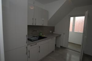 une cuisine avec des armoires blanches, un évier et une fenêtre dans l'établissement AB Stuttgart Untertürkheim, à Stuttgart