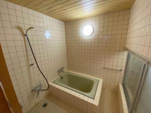 a bathroom with a bath tub in the corner at kakayama hutte in Muraoka