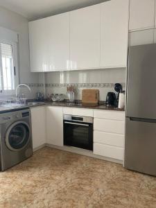 a kitchen with white cabinets and a washer and a dishwasher at Family Apartment in Orihuela +8 photos