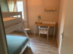 a small room with a bunk bed and a desk at Cocon proche centre ville in Embrun