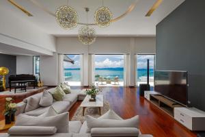 ein Wohnzimmer mit einem weißen Sofa und einem TV in der Unterkunft Villa Arun in Phuket