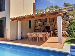 a patio with a table and chairs and a fireplace at Villa Barcelona en Olivella in Olivella