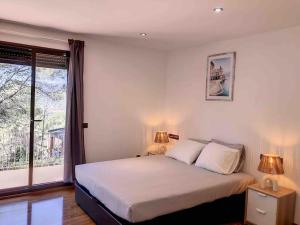 a bedroom with a bed with two lamps and a window at Villa Barcelona en Olivella in Olivella +54 photos