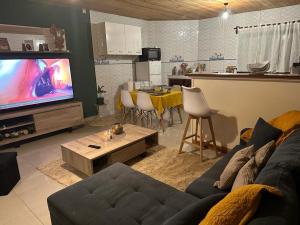 sala de estar con sofá y TV y cocina en Cœur d'or Sada, en Sada