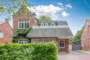 een rood bakstenen huis met een grijs dak bij Moenkevilla in Husum