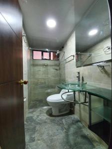 La salle de bains est pourvue de toilettes et d'un comptoir en verre. dans l'établissement Mirador Casa Blanca Campestre, à Tibasosa