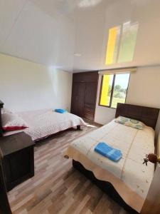 - une chambre avec 2 lits et une fenêtre dans l'établissement Mirador Casa Blanca Campestre, à Tibasosa