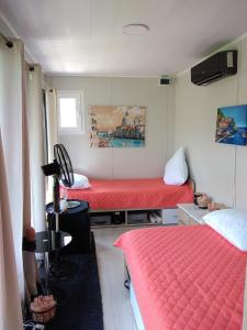 una camera con due letti con lenzuola rosse di Glamping pe Drum Transfagarasan srl a Curtea de Argeş