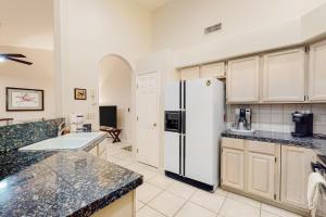 a kitchen with a white refrigerator and marble counter tops at Tucson National #8689 in Tucson