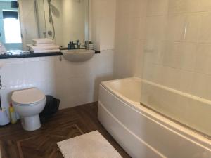 a bathroom with a tub and a sink and a toilet at Amazing converted water tower! in Coulsdon