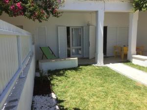 ein Haus mit einem Garten mit Stühlen und einem Tisch in der Unterkunft Apartamento perto da Praia Coelha in Albufeira