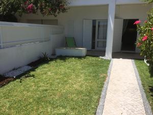 ein Haus mit einem Garten mit grünem Rasen in der Unterkunft Apartamento perto da Praia Coelha in Albufeira