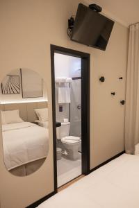 a mirror in a room with a bed and a toilet at Morada Inn Hotel in Franca