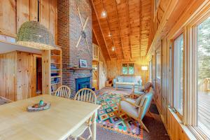a living room with a table and chairs and a fireplace at Tumblehome Cabin in Rangeley