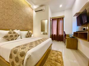 een hotelkamer met een bed en een televisie bij Arogyadham Retreat in Rishīkesh