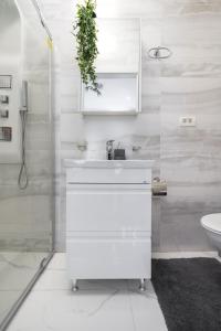 ein weißes Bad mit einem Waschbecken und einem WC in der Unterkunft Light-Monza-Unirii in Bukarest