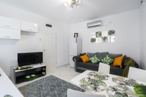 ein Wohnzimmer mit einem Sofa und einem TV in der Unterkunft Light-Monza-Unirii in Bukarest