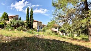 a house in the middle of a field with trees at Bastide de Ruety in Sillans-la Cascade