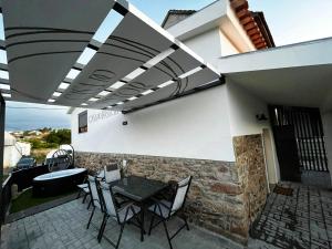 eine Terrasse mit einem Tisch und Stühlen sowie ein Gebäude in der Unterkunft Casa do Pastor in Carragozela