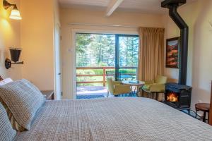 a bedroom with a bed with a fireplace and a balcony at Inn at Buckhorn Cove in Little River