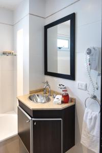 een badkamer met een wastafel en een spiegel bij Hotel Boutique Devoto in Buenos Aires