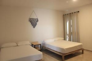 1 dormitorio con 2 camas y reloj en la pared en Yauik, en Tequesquitengo