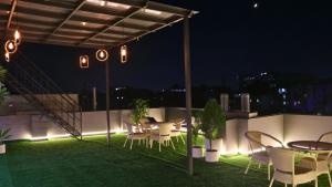a rooftop patio with tables and chairs at night at AVA Hotels and Corporate Suites in Gurgaon