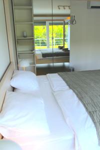 - un lit avec des draps et des oreillers blancs dans une chambre dans l'établissement Landhaus Anton, 