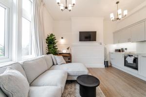 a living room with a couch and a kitchen at 2 The Quadrant Luxury Apartments - Hoylake in Hoylake