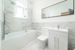 2 The Quadrant Luxury Apartments - Hoylake في هويليك: حمام أبيض مع مرحاض بالوعة ومرآة