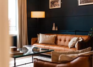 2 The Quadrant Luxury Apartments - Hoylake في هويليك: غرفة معيشة مع أريكة بنية وطاولة زجاجية