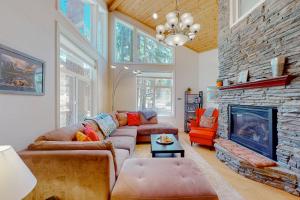 sala de estar con sofá y chimenea en Granite Tranquility, en Yosemite West