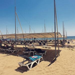 a beach with chairs and umbrellas on the sand at Colaklı Sunset Otel in Side