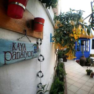 a sign on the side of a building with plants at Kaya Apart & Pansiyon in Bodrum City