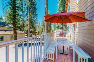 a porch with a bench and an umbrella at Granite Tranquility in Yosemite West