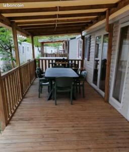 a patio with a table and chairs on a deck at sweet mobil-home in Lège-Cap-Ferret