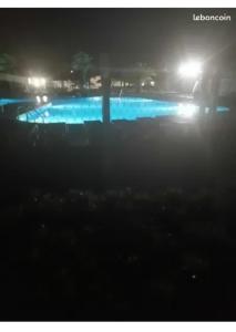 uma piscina à noite com as luzes acesas em sweet mobil-home em Lège-Cap-Ferret