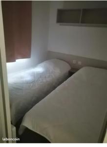 sweet mobil-home في ليج-كاب-فيري: غرفة نوم بسريرين في غرفة