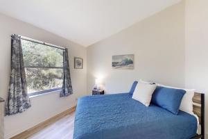 ein Schlafzimmer mit einem blauen Bett und einem Fenster in der Unterkunft The Barefoot Bungalow House in Palm Coast with an enclosed pool & grill in Palm Coast + 22 Fotos