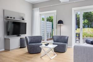 a living room with two chairs and a tv at Strandresidenzen Binz-Prora Strandresidenzen Binz-Prora V0 3 in Binz