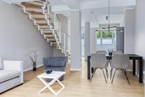 a living room with a staircase and a table and chairs at Strandresidenzen Binz-Prora Strandresidenzen Binz-Prora V0 3 in Binz