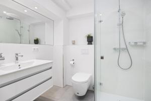 a white bathroom with a toilet and a shower at Strandresidenzen Binz-Prora Strandresidenzen Binz-Prora V0 3 in Binz +9 photos