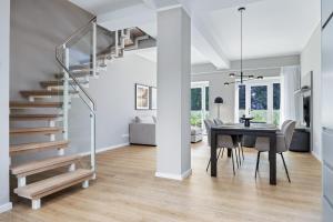 a dining room and living room with a table and stairs at Strandresidenzen Binz-Prora Strandresidenzen Binz-Prora V0 2 in Binz +9 photos