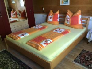 a bedroom with a large bed with orange pillows at Tschengla Ferienwohnung in Bürserberg