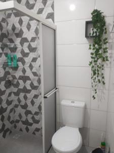 a bathroom with a toilet and a plant in it at Residencial Adventus II in Venâncio Aires