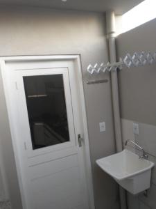 a bathroom with a white door and a sink at Residencial Adventus II in Venâncio Aires