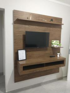 a entertainment center with a television on a wall at Residencial Adventus II in Venâncio Aires