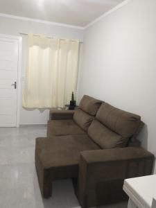 a brown couch in a living room with a window at Residencial Adventus II in Venâncio Aires