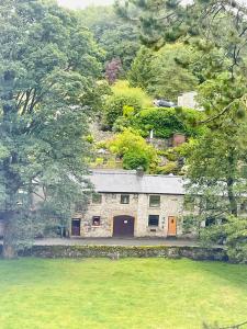 a stone house with orange doors in the middle of a field at The Beautiful Bobbin - Premium Place to stay - Cottage with views, local walks & pubs in Tideswell
